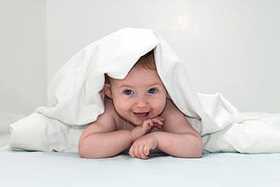 baby showing face under white blanker HD wallpaper